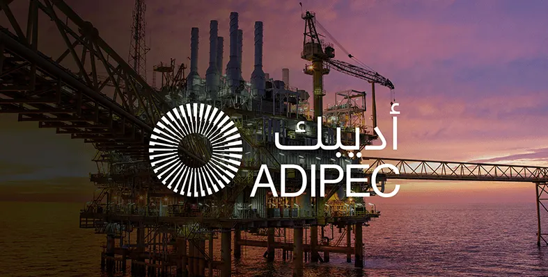 Offshore oil rig at sunset overlaid with ADIPEC logo