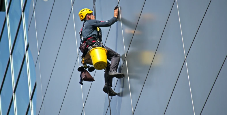 A worker scaling a building