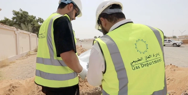 Two_men_wearing_hard_hats_inspecting_gas_pipeline 