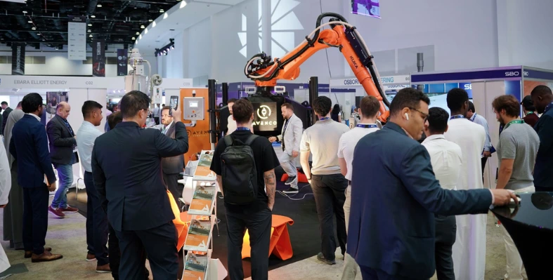 many_people_seen_at_a_conference_with_machinery_in_the_background