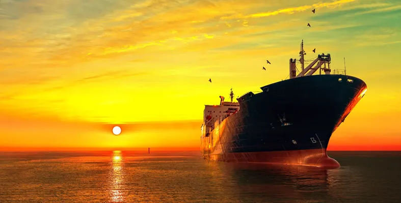 Oil tanker against yellow sunset sky