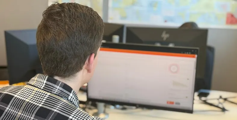 Man sitting next to a computer screen