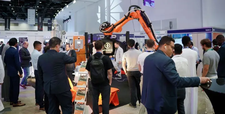 many_people_seen_at_a_conference_with_machinery_in_the_background