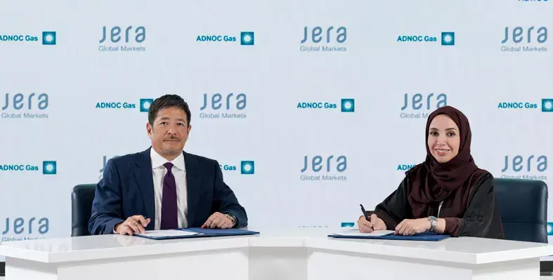 The LNG will be supplied from ADNOC Gas’ Das Island liquefaction facility. (Image source: ADNOC Gas) Man and woman signing agreement against JERA company logo background