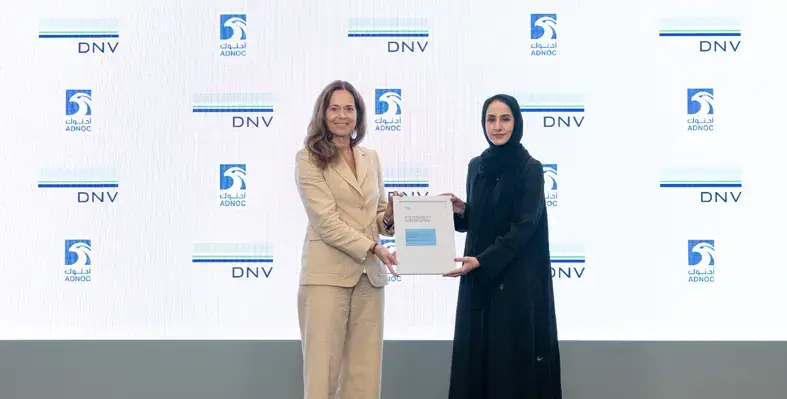 Liv Hovem and Hanan Balalaa hold a certificate with company logos in background