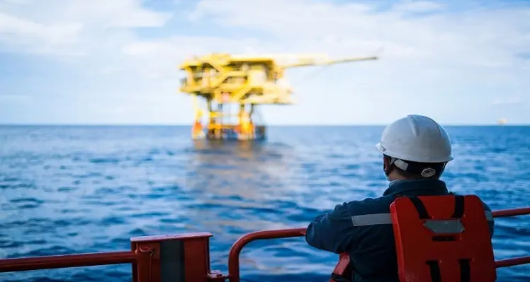 Operators have never needed to take safety and efficiency more seriously. (Image source: Adobe Stock) Picture of an oil worker and offshore oil rig
