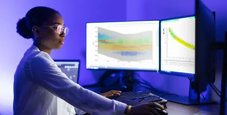 In the Middle East, Stream telemetry helped a major operator overcome difficulty in geosteering operations caused by harsh drilling conditions. (Image source: SLB) Woman seated in front of a computer screen