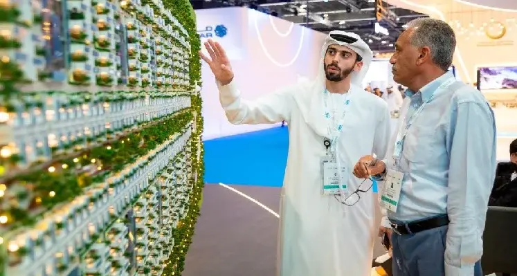 The World Future Energy Summit 2024 will bring together industry leaders, policymakers, investment incubators, corporate partners, and world-class startups. (Image source: RX) Picture of two men looking at a sustainable technology innovation at trade show.